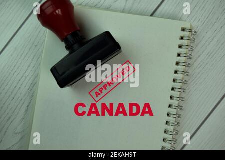 Red Handle Rubber Stamper and Approved Canada text isolated on Brown burlap laying on table Stock Photo
