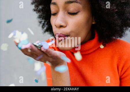 Young woman blowing confetti Stock Photo