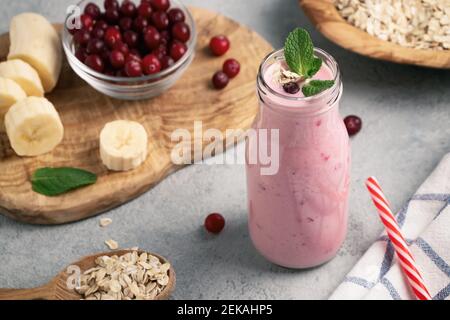 Homemade yogurt smoothie with banana, cranberry and oatmeal. Stock Photo