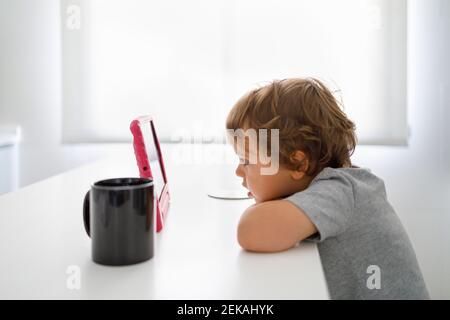 Father and son using digital tablets in kitchen Stock Photo