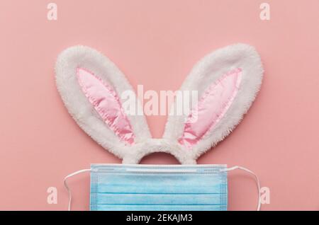 Coronavirus Easter bunny face made from rabbit ears and a protective face mask Stock Photo
