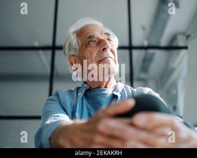 Thoughtful businessman looking away while sitting at office Stock Photo