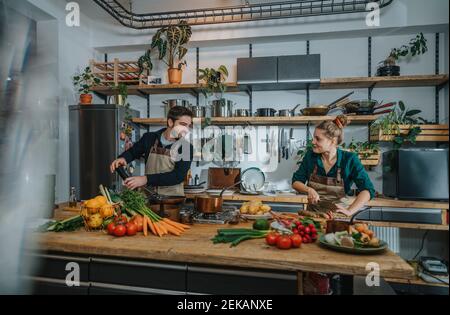 Chefs smiling while working in kitchen Stock Photo