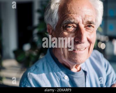 Smiling businessman staring while standing at office Stock Photo