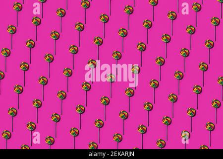 Pattern of multi colored lollipops against pink background Stock Photo
