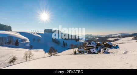 Germany, Baden-Wurttemberg, Sankt Margen, Sun shining over houses of town in middle of Black Forest in winter Stock Photo