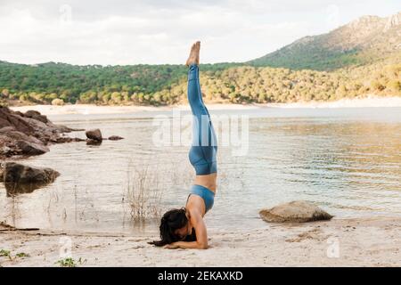 Young woman doing Pincha Mayurasana yoga Stock Photo