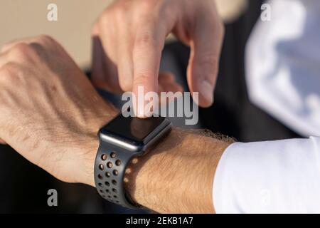 Close-up of businessman using smart watch outdoors Stock Photo