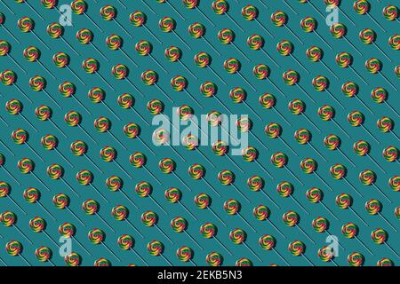 Pattern of multi colored lollipops against green background Stock Photo