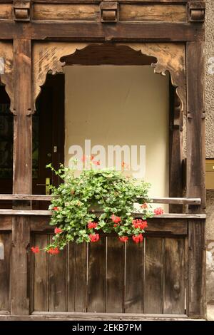 Facade of a house in Liechtenstein, with a beautifully carved wooden porch and decorative flowers Stock Photo