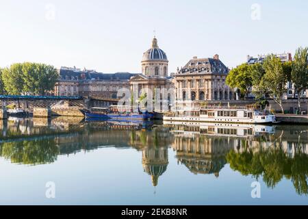 France, Ile-de-France, Paris, Institut de France reflecting in river Seine Stock Photo