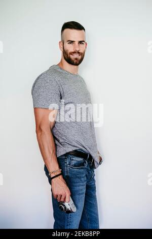 Smiling young man holding vintage camera Stock Photo