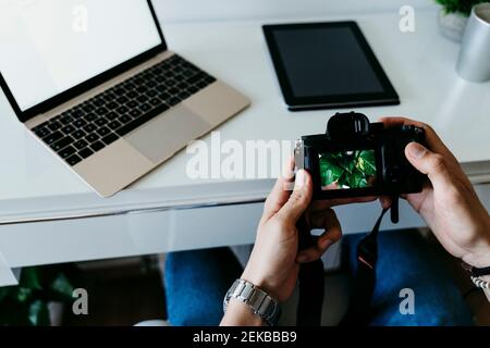 Man working with camera and laptop at home Stock Photo