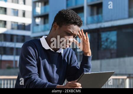 Serious young man with digital tablet against building Stock Photo
