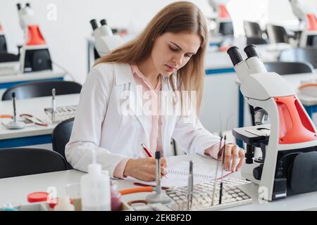 Young female researcher working in science class Stock Photo