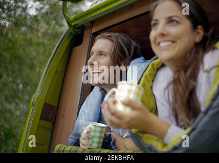 Couple having coffee in campervan while enjoying road trip Stock Photo