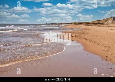 Waves lap up on a sandy beach on the north shore of Prince Edward Island, Canada. Stock Photo