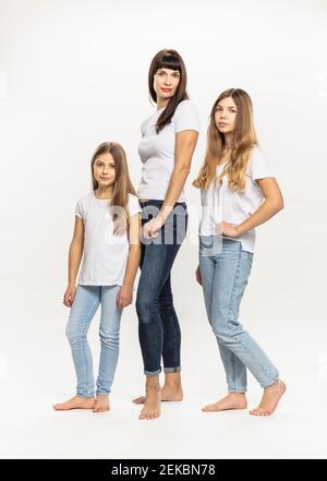 Mother standing with daughters against white background Stock Photo