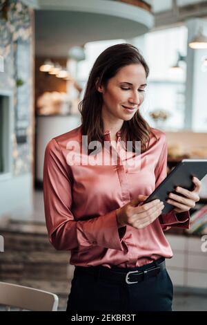 Smiling businesswoman using digital tablet at cafe Stock Photo