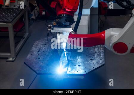 Close-up of automatic robotic arm welding metal in factory Stock Photo