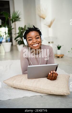 Smiling female entrepreneur using digital tablet at home Stock Photo