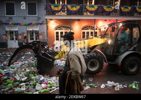 Bulldozer cleaning Trash-filled streets late night morning after Mardi Gras, New Orleans, Louisiana, USA. Bourbon Street. Stock Photo