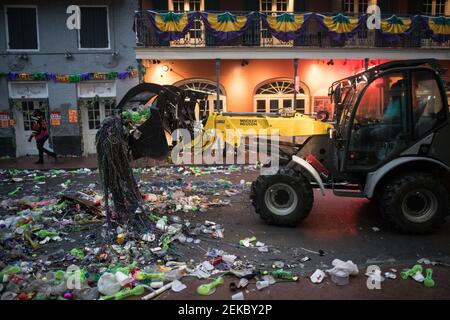 Bulldozer cleaning Trash-filled streets late night morning after Mardi Gras, New Orleans, Louisiana, USA. Bourbon Street. Stock Photo