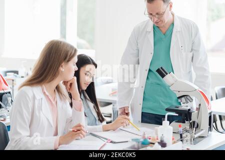 Students and teacher working in science class Stock Photo