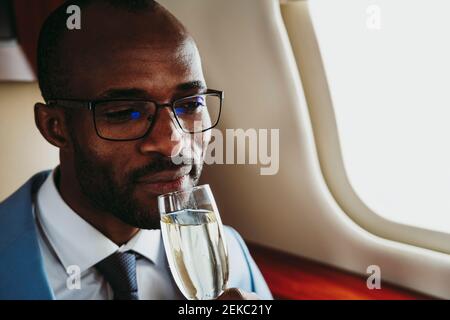 Businessman drinking champagne in private jet Stock Photo