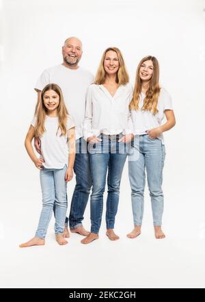 Smiling mother and father with daughters against white background Stock Photo