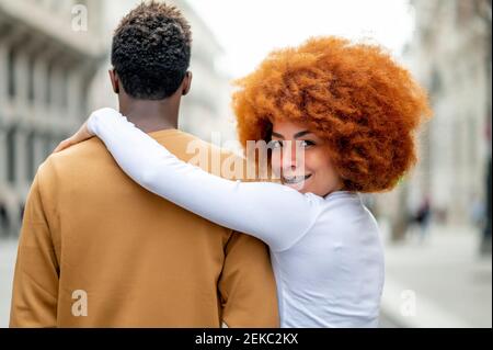 Girlfriend staring while standing with arm around boyfriend outdoors Stock Photo