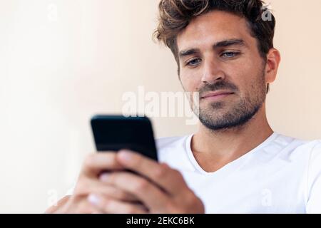 Serious man using smart phone at home Stock Photo