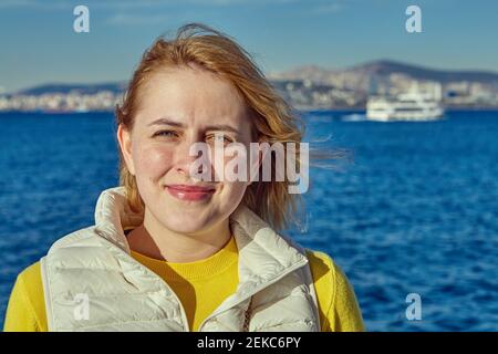 Young European woman stands against backdrop of Sea of Marmara near Istanbul, Turkey. Stock Photo
