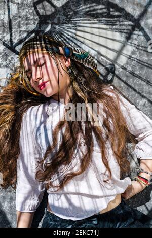 Close-up portrait of hippie woman gesturing against wall Stock Photo