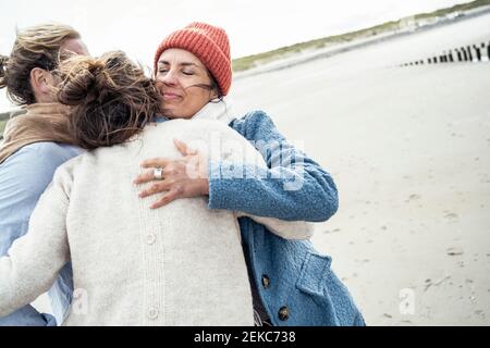 Group of friends hugging on beach Stock Photo