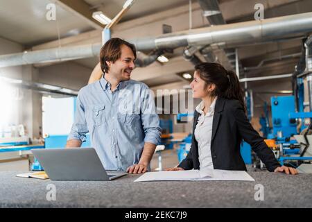 Young expertise with laptop having discussion while working at industry Stock Photo