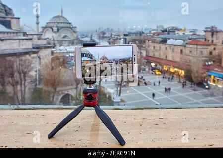 Smartphone holder is attached to tripod for recording video in travel vlog. Video blogger uses mobile phone to stream from Istanbul. Stock Photo