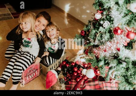 Happy family decorating Christmas tree together at home Stock Photo