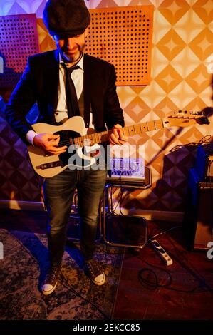 Male guitarist in smart casuals practicing at studio Stock Photo