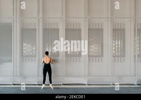 Female ballet dancer practicing in front of Metal wall Stock Photo