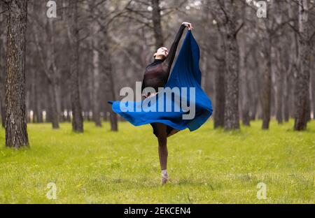 Young ballet dancer spinning while dancing in forest Stock Photo