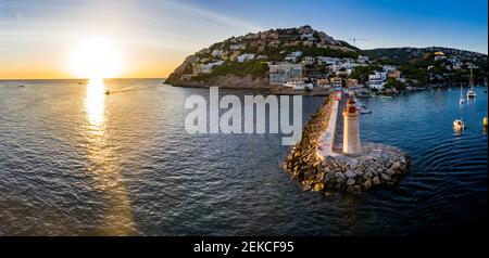 Spain, Balearic Islands, Andratx, Helicopter view of coastal town and Port D Andratx Lighthouse at sunset Stock Photo