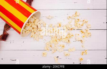 Popcorn, film on a white wooden background, top view. The concept of cinema. Stock Photo