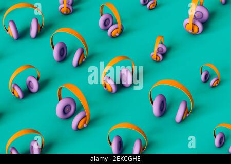 Small and large multi colored headphones on green background Stock Photo