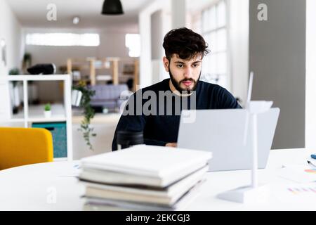 Young businessman using laptop in creative office Stock Photo