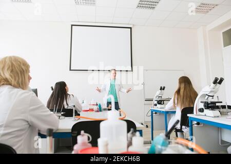 Students and teacher working in science class Stock Photo