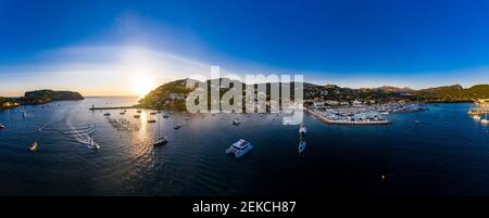 Spain, Mallorca, Andratx, Helicopter view of boats sailing near shore of coastal town at summer sunset Stock Photo