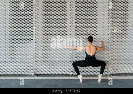 Female dancer practicing ballet dance in front of metal wall Stock Photo
