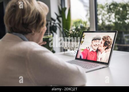 Senior woman on video call with friends through laptop at home Stock Photo