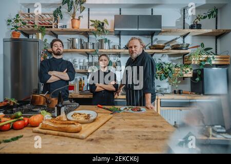 Confident chef staring while standing by kitchen counter in kitchen Stock Photo